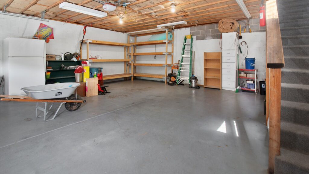 Residential garage with shelves, tools, a wheelbarrow and storage cabinets