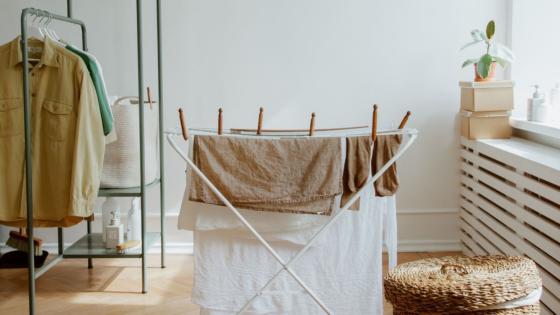 Wicker laundry basket beside clothes drying in a sunlit room