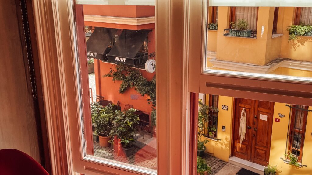 Small table beside a residential window overlooking a narrow street