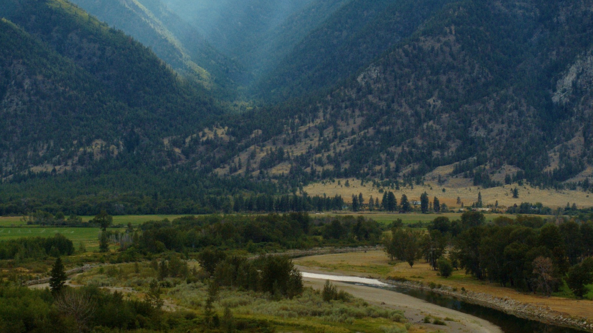 Similkameen River winding through a green valley below forested hills near Keremeos, British Columbia